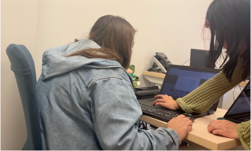 a student works with a woman who is using her computer at the Carroll Center